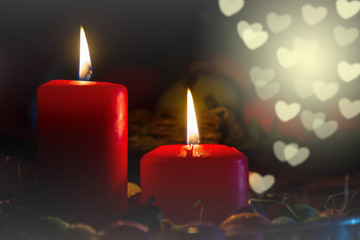 It's holiday time! Red candles on a dark background, an indispensable detail when the holidays. Abstract hearts in background.