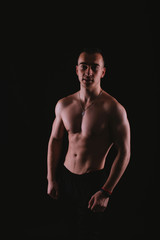Fototapeta premium Portrait of young handsome sportsman bodybuilder over dark background