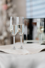 Wine glasses on the table full with champagne on the blurred background