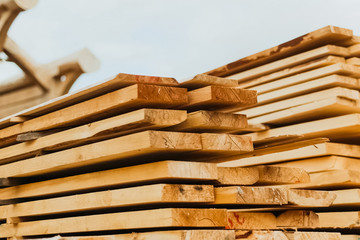 Folded boards and logs on construction site.