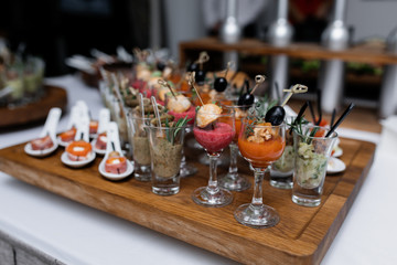 Fruit smoothies and snacks in glassware on the wooden tray