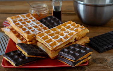des gaufres , natures et  couvertes de chocolat sur une table rustique
