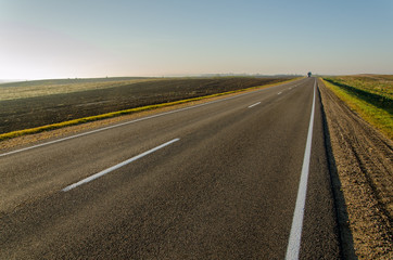 hitchhiking, empty road, freedom of choice. car on the highway on a sunny day.