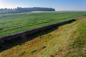 old stone fence. Autumn landscape. Clear sunny day. Shchrana historical heritage