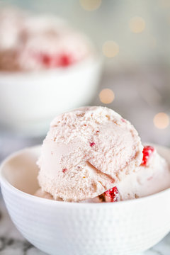 Strawberry ice cream with chunks of strawberries in a bowl. Selective focus with blurred background.