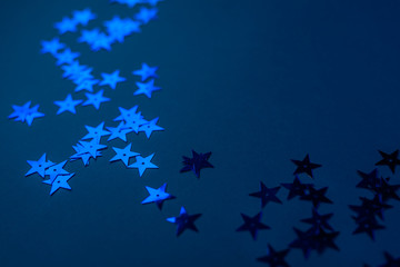 Stars confetti on classic blue background, horizontal. Color 2020. Blue asterisks confetti.