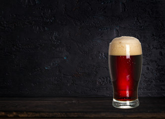 Glass of beer on wood dark background with copyspace for text