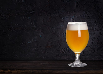 Glass of beer on wood dark background with copyspace for text