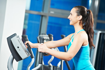 Fototapeta na wymiar Cardio training. Woman and man at cross-trainers in gym