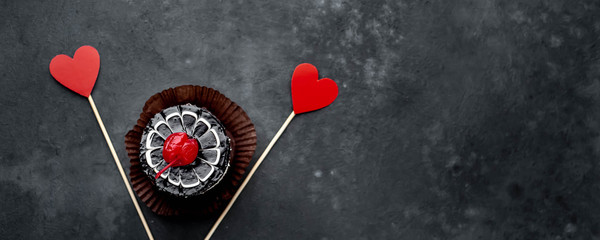 cherry cheesecake with carved hearts from  red paper on a stone background with copy space for your text. Breakfast concept for a loved one on Valentine's Day
