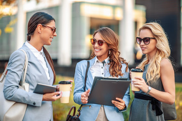 Three businesswomen in front of their workplace