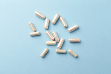 Carnitine and Korean Ginseng capsules. Energy and focus support. Concept for a healthy dietary supplementation. Bright paper background. Top view. 