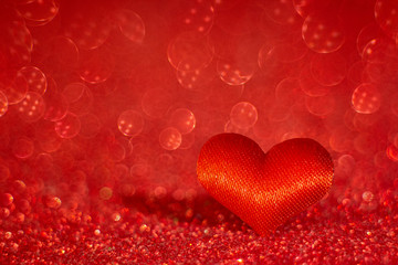 Red heart on blurred red bokeh background. Symbol of love. Valentine's Day