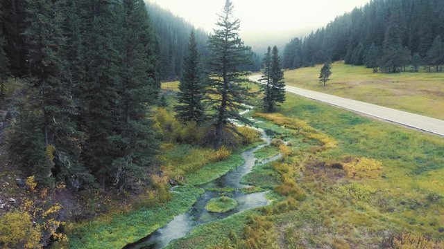 Aerial floating down a river flowing through the autumn colored Black Hills National Forest. South Dakota, USA