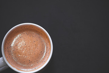 white cup of coffee with black wooden background