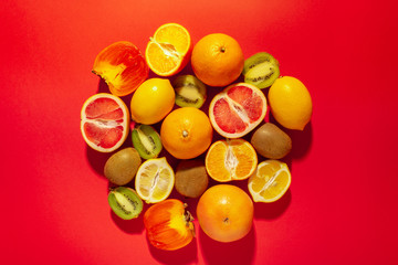 Flat lay composition with tangerines and citrus fruits on red background