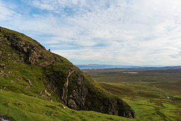 Fototapeta na wymiar Woman sitting on a mountain at Quiraing on the Isle of Skye
