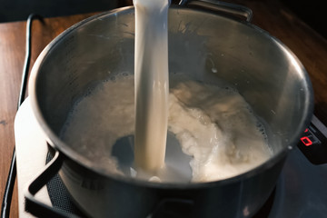 Pouring milk into the pan on scales.