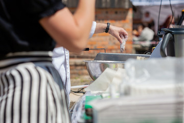 A man prepares fish for frying at a street food festival