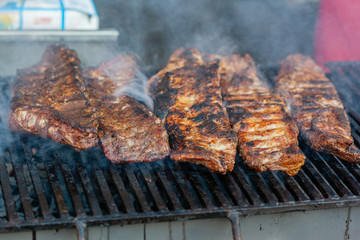 Grilled pork ribs on the grill at street food festival