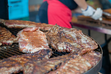 Grilled pork ribs on the grill at street food festival
