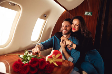 My man. A lovely woman is hugging her attractive husband from the back while taking a flight with...