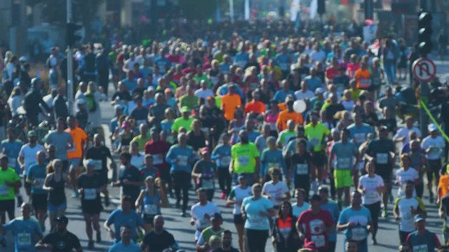 Blurry shot of marathon runners jogging on a street