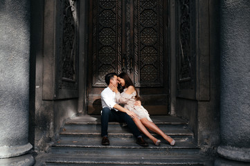 Couple in love cuddles sitting on the steps, outdoors