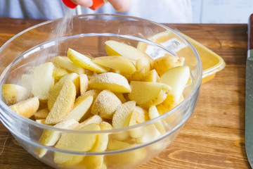 Raw potatoes cutting and peeling on table in a plate