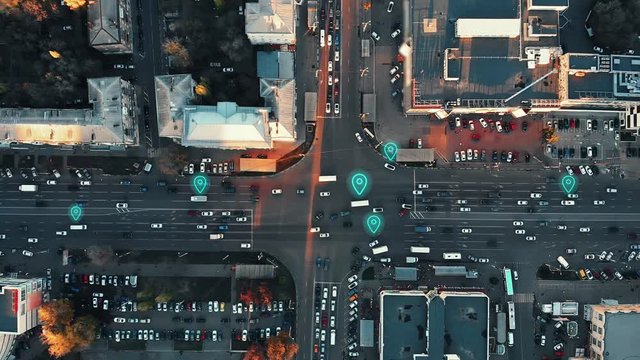 Aerial view of city intersection with many cars and GPS navigation system symbols. Autonomous driverless vehicles in city traffic. Future transportation concept