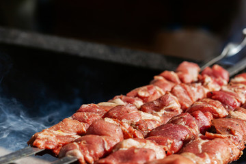 Grilling marinated meat on a grill. Street food festival