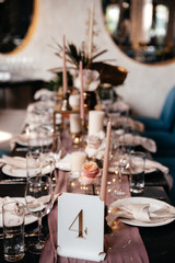 Festive table with a name of table, with a lot elements of decora flowers and candles, indoors. Close-up