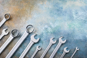 Wrench spanner tools on grunge colorful background. Top view, copy space.