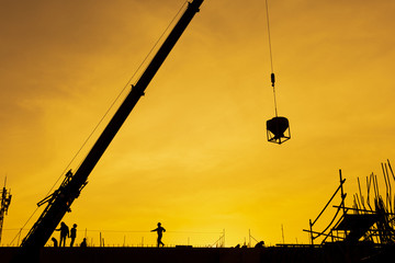 Silhouette of engineer and construction team working at site with sunset