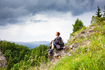Fototapeta premium woman hiker with raincoat looking at beautiful spring landscape