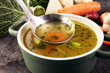 Broth with carrots, onions various fresh vegetables in a pot - colorful fresh clear spring soup. Rural kitchen scenery vegetarian bouillon stock - 314374855