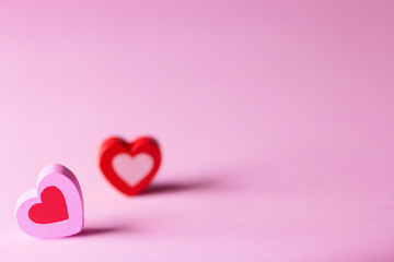 Valentines day concept. Two wooden hearts on a pink surface.  A symbol of love happiness and devotion. 