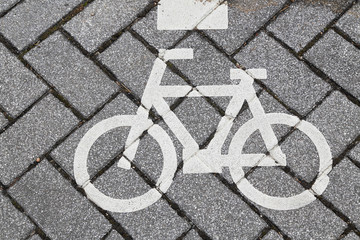 Fototapeta na wymiar White Sign of Bicycle lane painted over cement block path