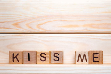 The phrase Kiss Me. Kiss me on wooden cubes. Love theme. Valentine's day. Wood letter blocks with words Kiss Me. Love, positive emotions. Wood cubes with phrase Kiss Me