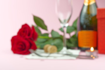 a composition of a beautiful bouquet of roses, glasses and a bottle of champagne creates a romantic bokeh background. The concept of st valentine's day, Mother's Day, March 8.