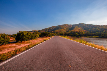The blurred panoramic nature background of sunlight hitting the lake's surface, grass and wind blowing all the time along the large mountains, ecological beauty and fresh air.