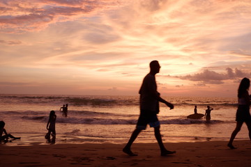 silhouette of a man walking on the beach at sunset