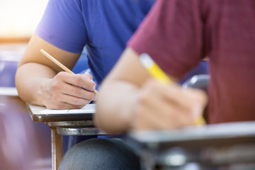 high school,university student study.hands holding pencil writing paper answer sheet.sitting lecture chair taking final exam attending in examination classroom.concept scholarship for education abroad