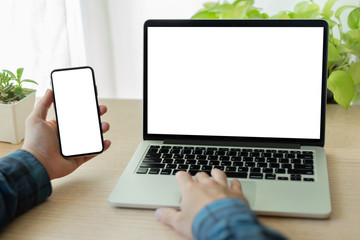 mockup image blank screen computer,cell phone with white background for advertising text,hand man using laptop texting mobile contact business search information on desk in cafe.marketing,design