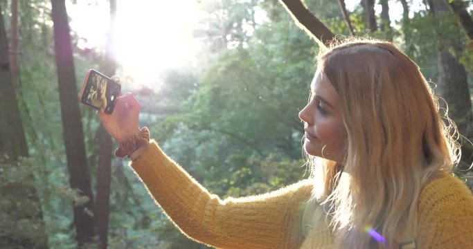 Female girl taking photo selfie outdoors in nature forest woods for social media