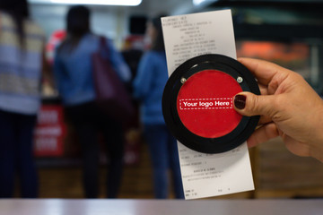 Hand showing Invoice with Wireless calling system restaurant or pager customers system  and person row background.