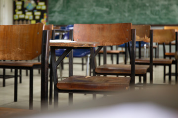 selective soft and blur focus.old wooden row lecture chairs in dirty classroom in poor school.study room without student.concept for education in third world ,donate and charity,background text.