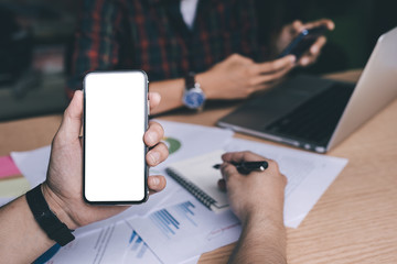 Mockup image blank white screen cell phone.man hand holding texting using mobile on desk at office.background empty space for advertise text.people contact marketing business,technology 