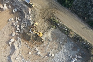 Excavator Filling up Dump Trucks at Construction Project