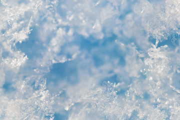 Background from crystal clear real snowflakes in blue and turquoise shades in macro with copy space...